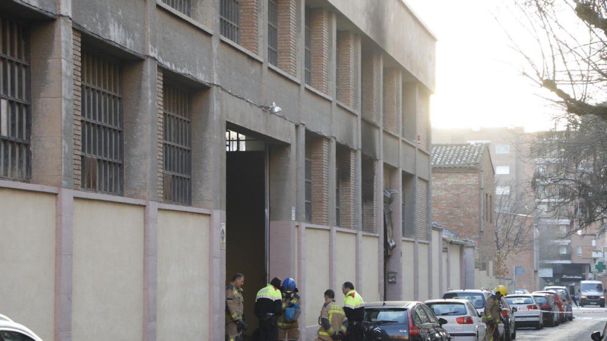 Agentes de los Mossos d'Esquadra y bomberos ayer por la mañana tras el incendio en la nave.