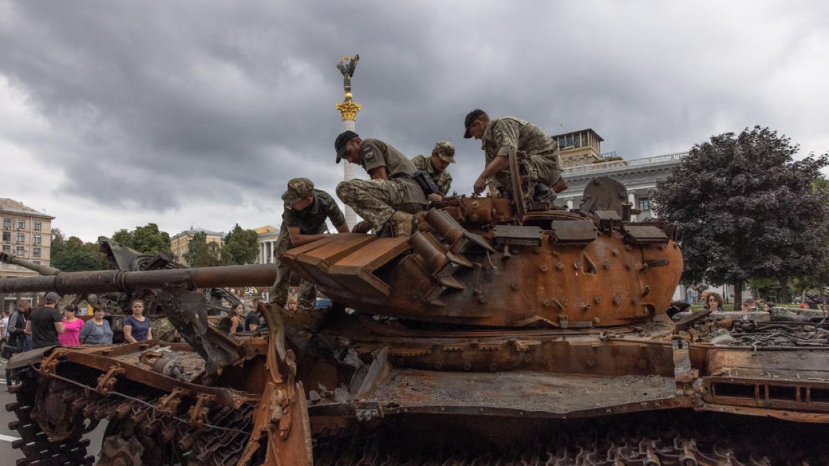 Soldados ucranianos sobre un tanque ruso destruido exhibido en el centro de Kiev.