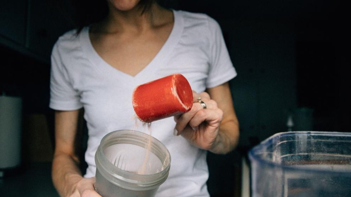 Imagen de archivo de una persona preparando un batido con proteina en polvo.