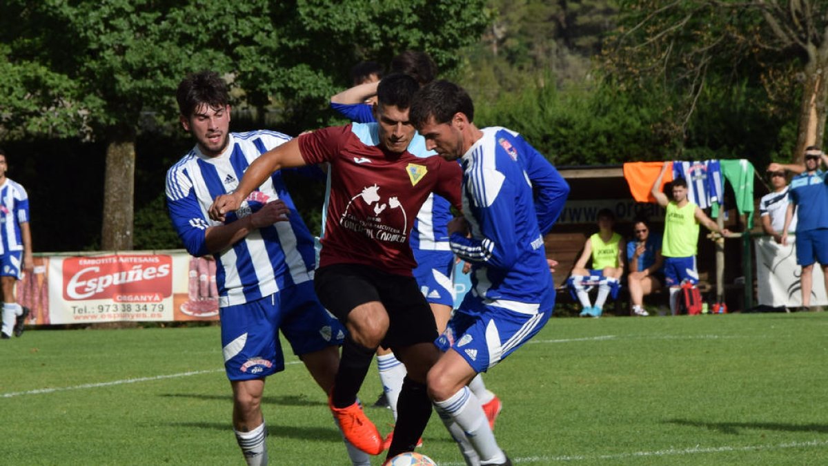 Un jugador de la Seu d’Urgell mira de superar dos rivals en una jugada del partit.