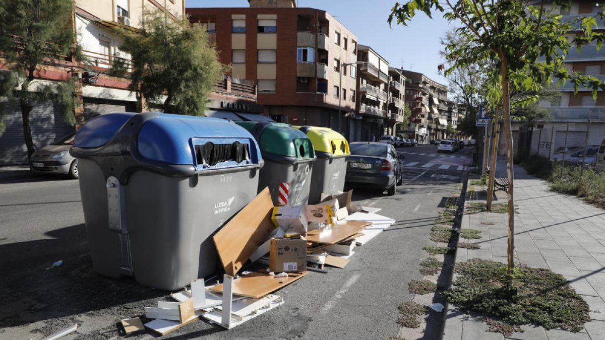 Caixes al costat d’un contenidor de paper i cartró a la plaça Santa Maria Magdalena (Clot).