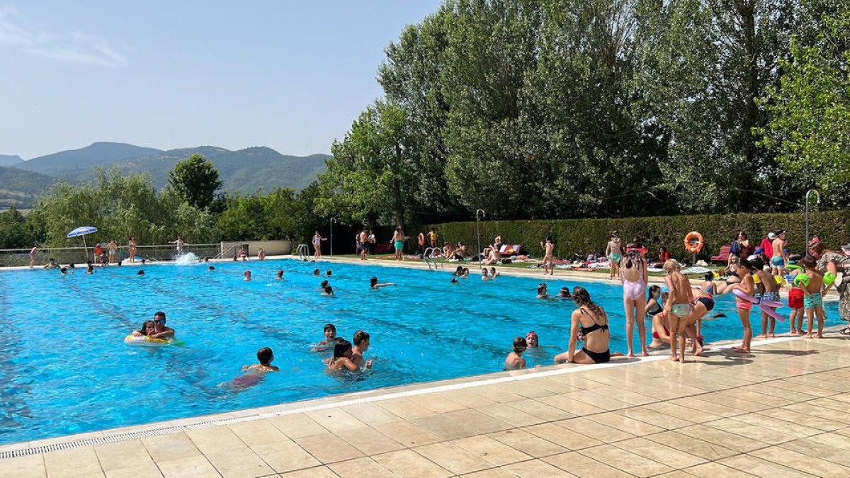 Varios niños en el recinto de las piscinas municipales de la Seu d'Urgell refrescándose en un día de calor extremo