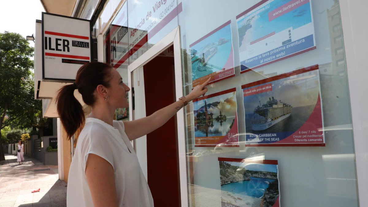 Una usuària mira ofertes de viatges en l’agència Ilertravel de Lleida.
