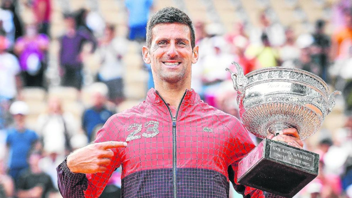 Djokovic sosté la copa i assenyala el número 23 a la caçadora, els títols de Grand Slam que té.