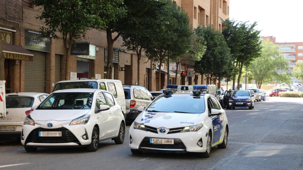 Imatge del CiviCar passant just al costat d’un cotxe aparcat en doble fila en aquest barri.