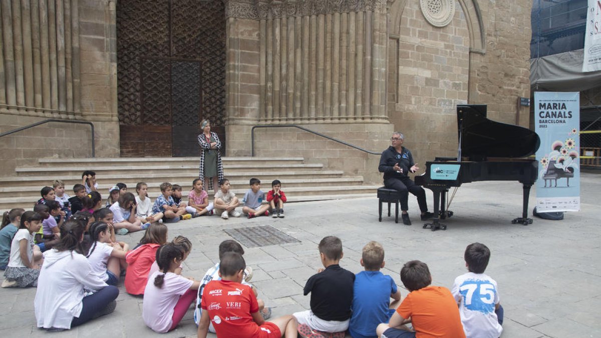 Un grupo de escolares, ayer ante el piano instalado en la plaza de L’Església de Agramunt.