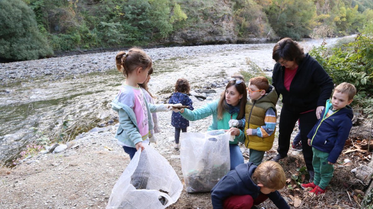 Escolars recullen escombraries al costat del riu a Rialp.