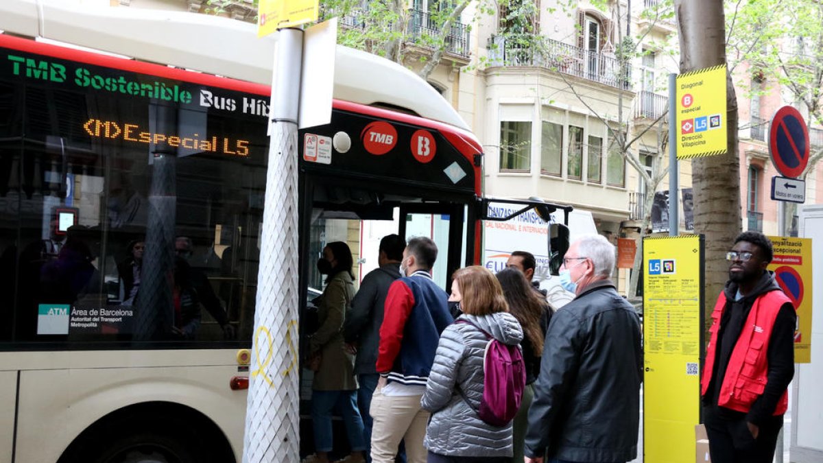 Usuarios esperan subir al bus en Barcelona.