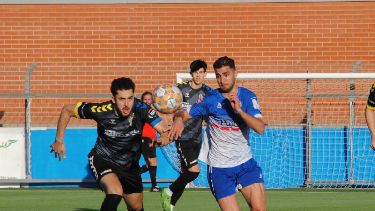 Nico Magno pugna per una pilota aèria amb un rival de la Guineueta, ahir durant el partit al Municipal de Mollerussa.