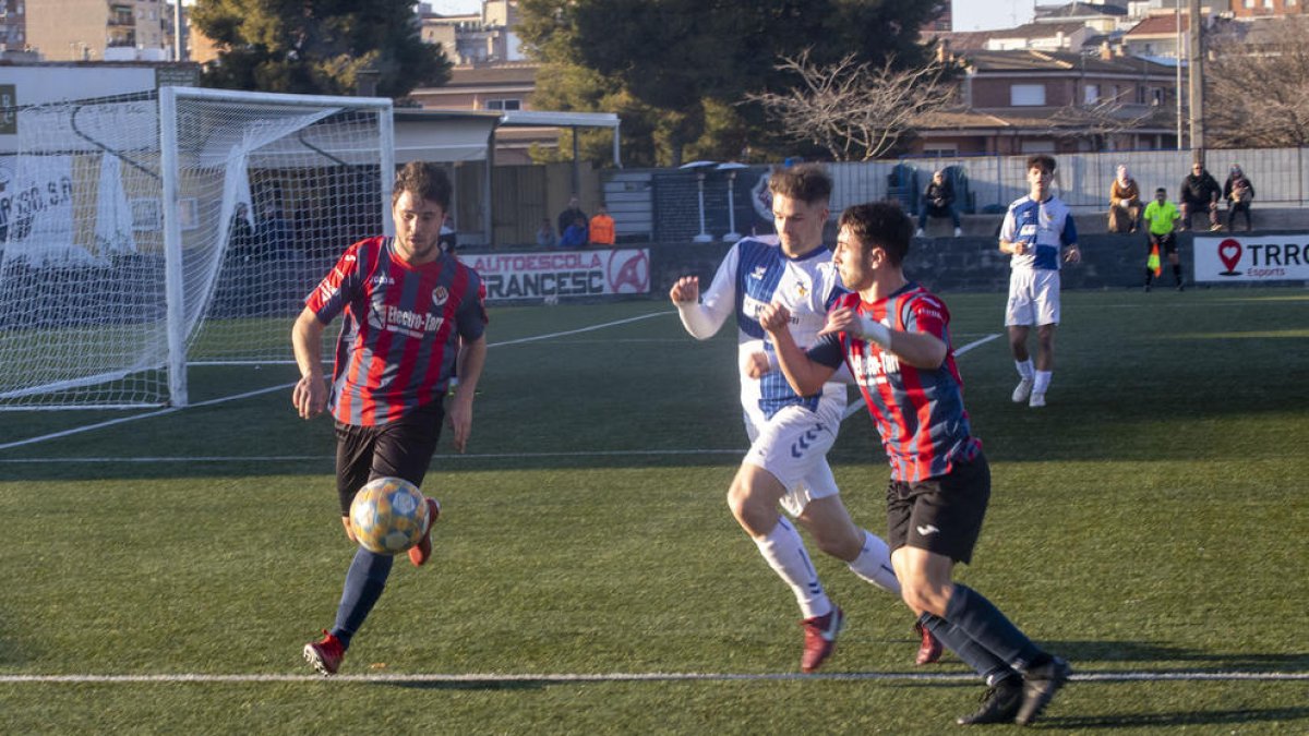 Jugadors del Tàrrega i del Sabadell B pugnen pel control de la pilota. 