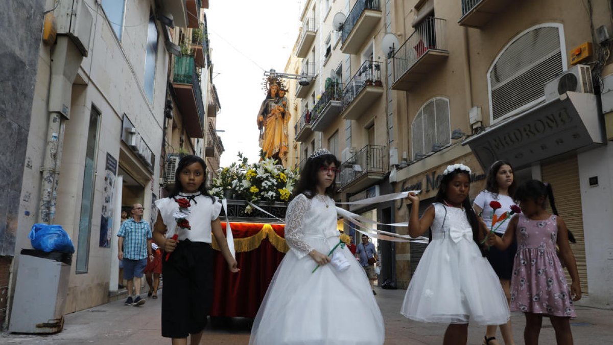 Joves que han rebut la Primera Comunió aquest any van acompanyar en processó la Verge del Carme.