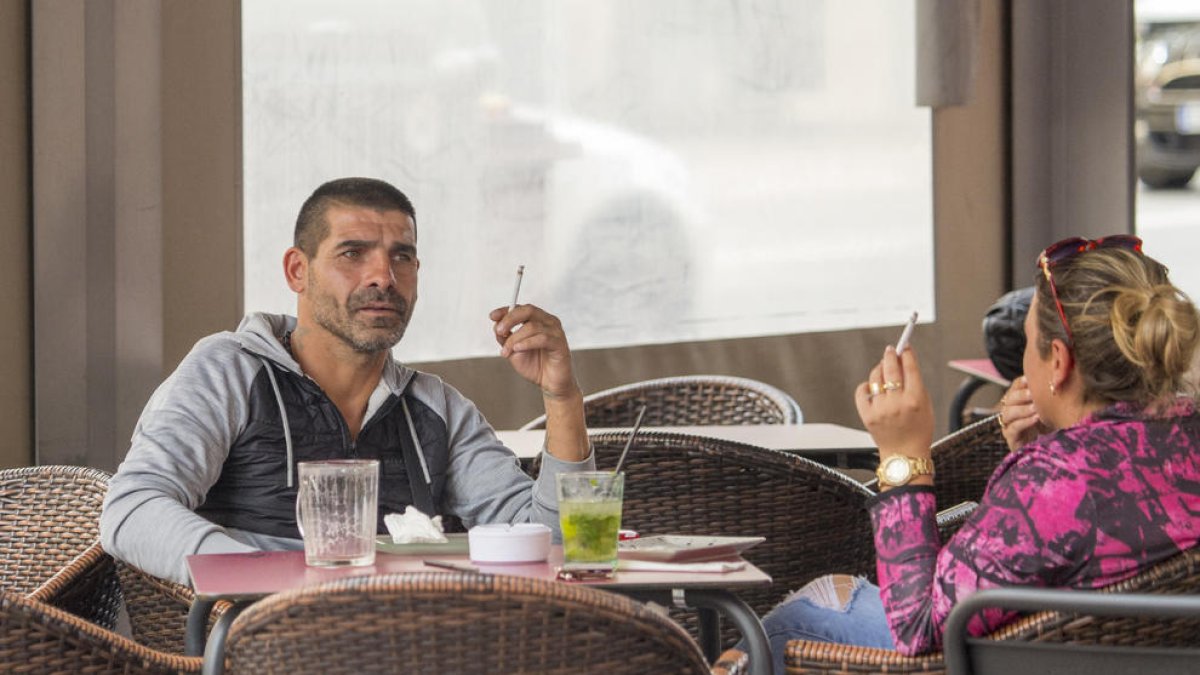 Consumidores fumando en la terraza de un establecimiento en Lleida. 