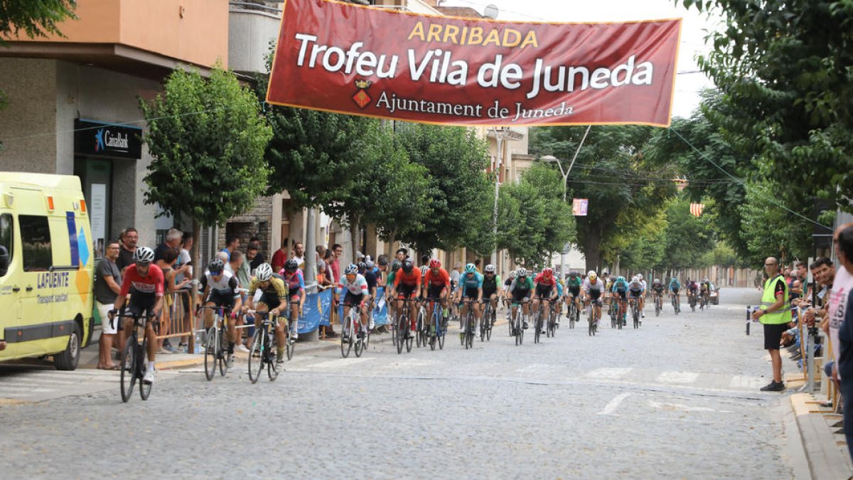 El pelotón de la prueba, a su paso por la línea de meta, en una de las vueltas por el circuito.