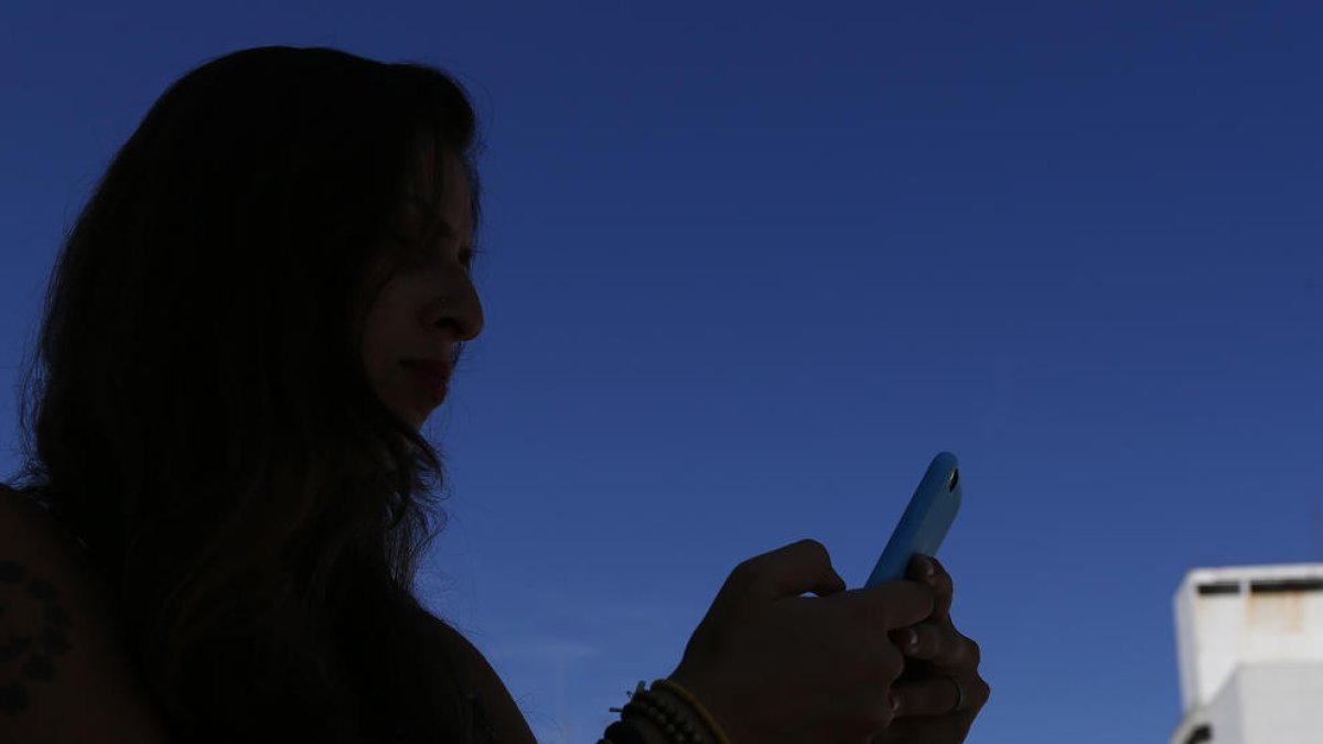 Una mujer mirando su teléfono.