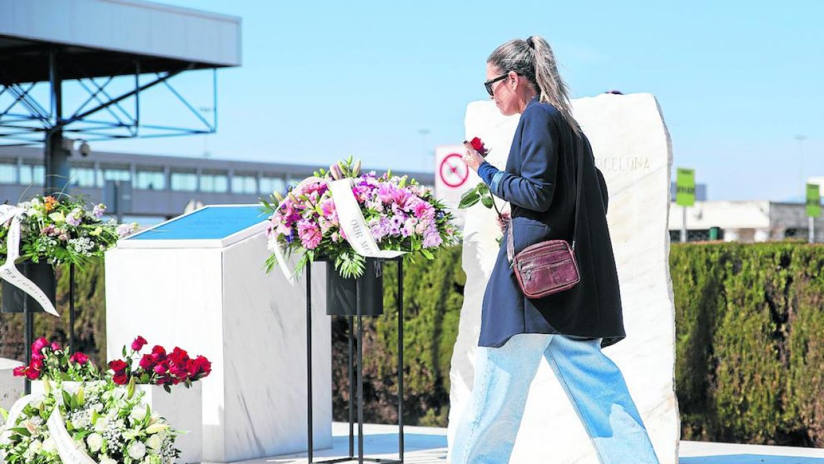 Una mujer participa en el homenaje a las víctimas en el aeropuerto de El Prat el 23 de marzo.