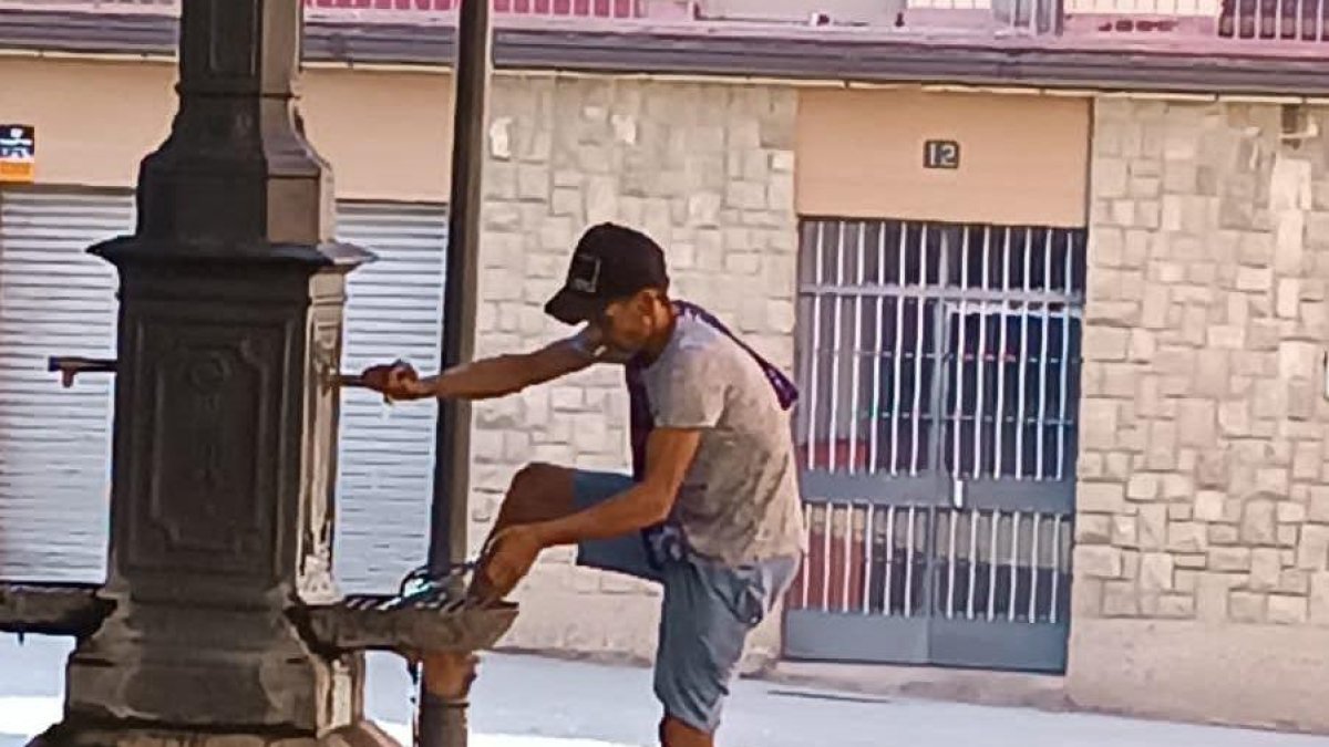 Una persona rentant-se els peus en una font pública