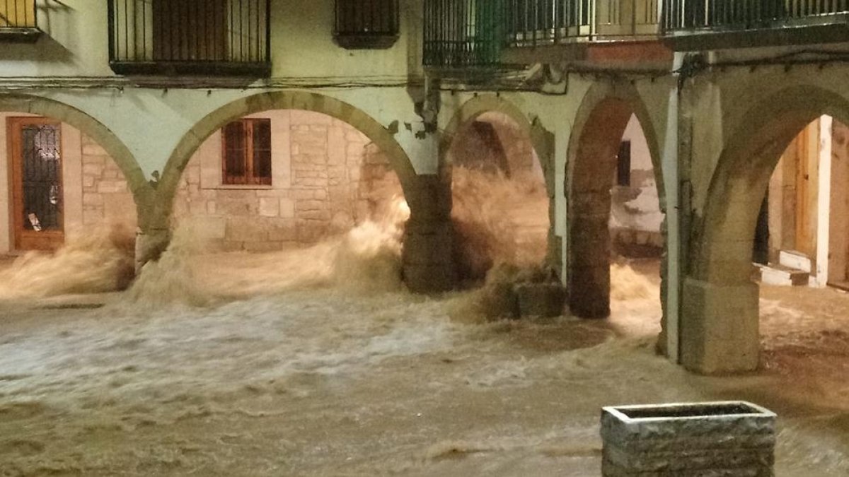 La plaza Major de L’Albi completamente inundada el 22 de octubre de 2019 (en la imagen izquierda) y su aspecto actual tras las obras de mejora que se han ejecutado. 