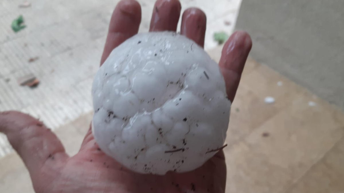 Una persona aguanta una piedra que ha caído este martes por la tarde en Corçà.