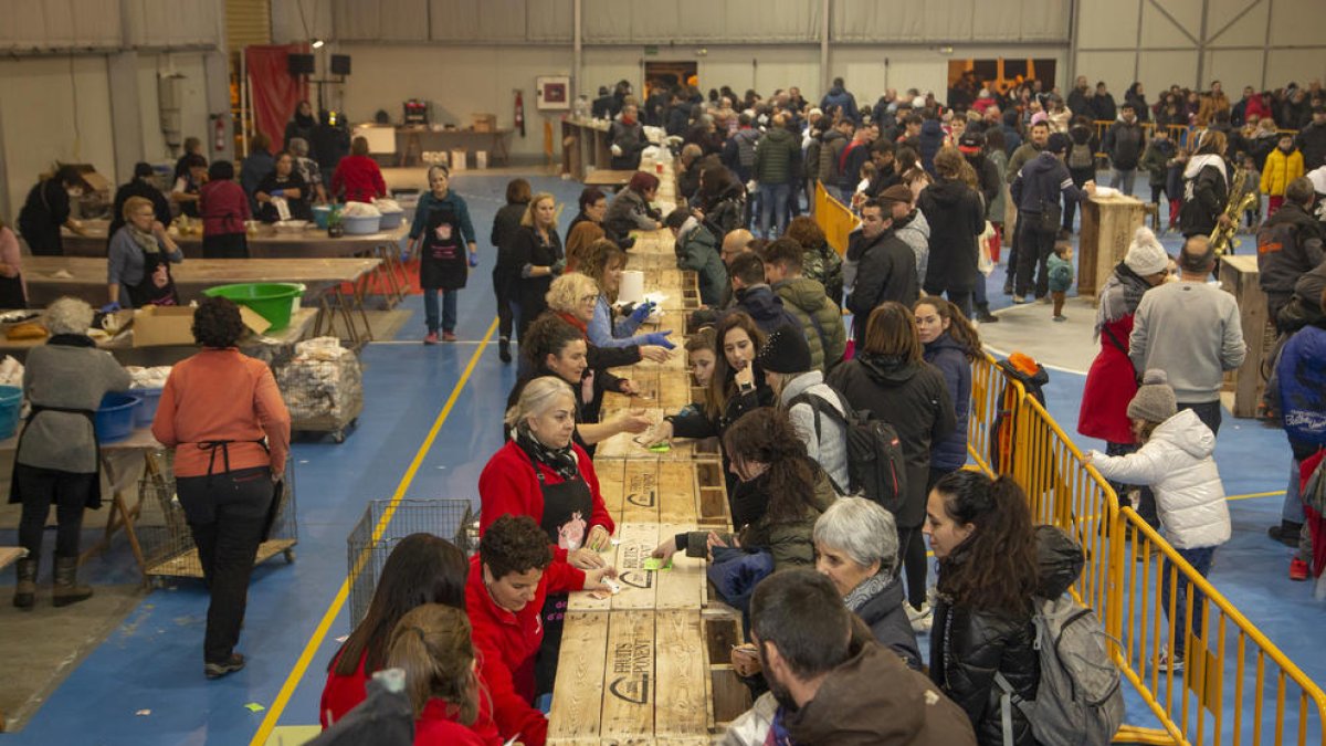 Centenars de veïns d’Alcarràs van fer cua ahir per recollir un entrepà de llonganissa i botifarró.