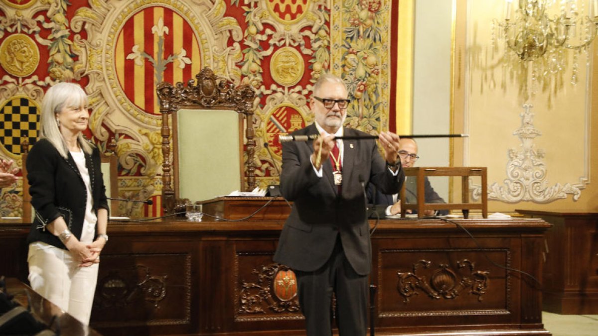 Fèlix Larrosa mostrant la vara d’alcalde que li va entregar Neus Caufapé, la regidora de més edat.