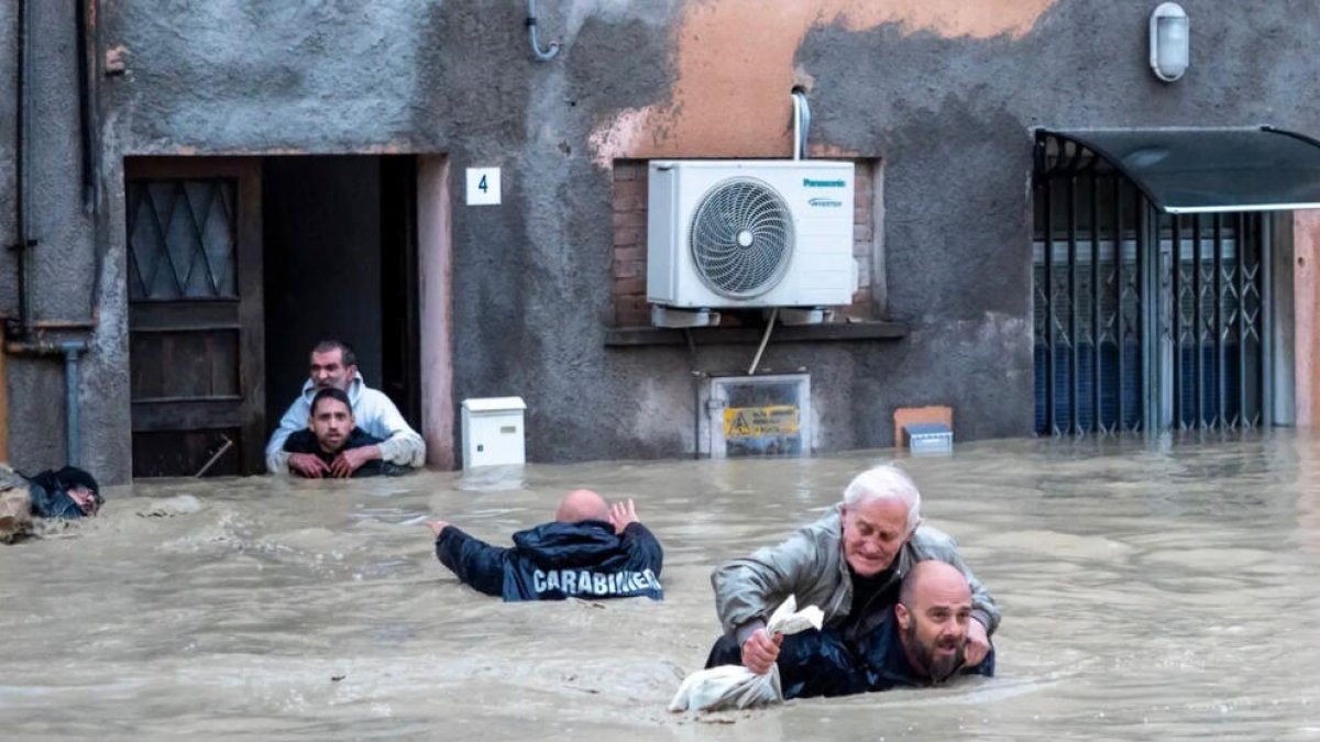 Agentes de los Carabinieris italianos, evacuando a varias personas de su residencia inundada en la localidad de Faenza.