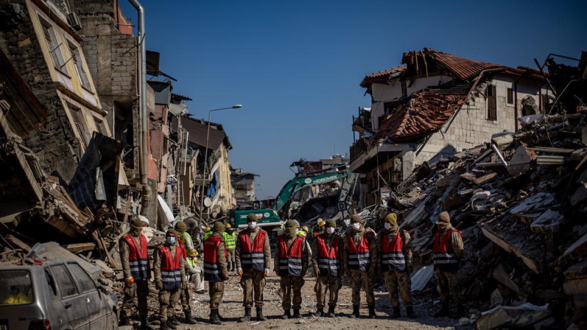 Un equipo de rescate camina entre edificios derribados por los sismos en Antioquia, Turquía.