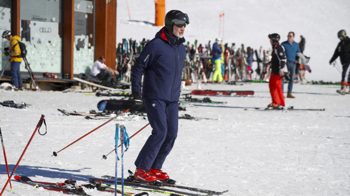 El rei Felip VI esquiant ahir a Baqueira (esquerra) i un gran nombre d’esquiadors a l’estació de Port Ainé, que va tancar l’accés al completar l’aforament.