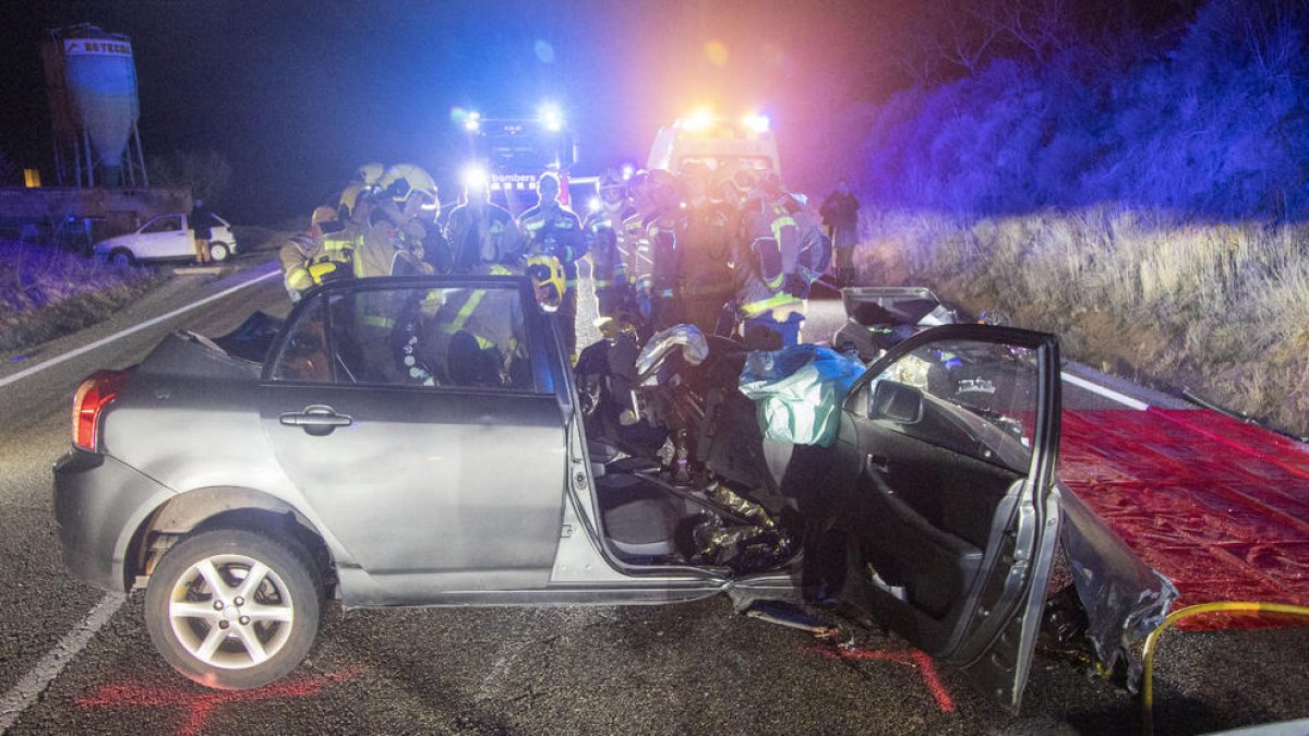 Efectivos de los Bomberos inspeccionan uno de los vehículos accidentados en Ciutadilla. 