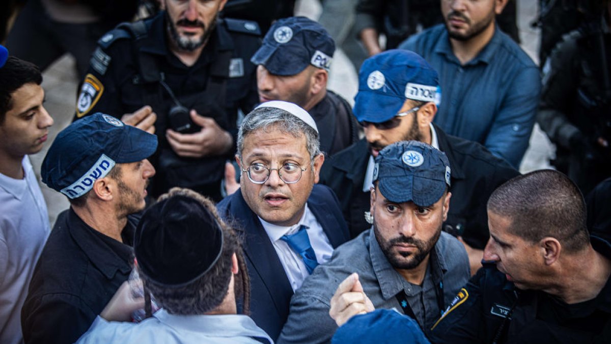 El ministro de Seguridad Nacional de Israel, Itamar Ben Gvir, protegido por la policía en una marcha.