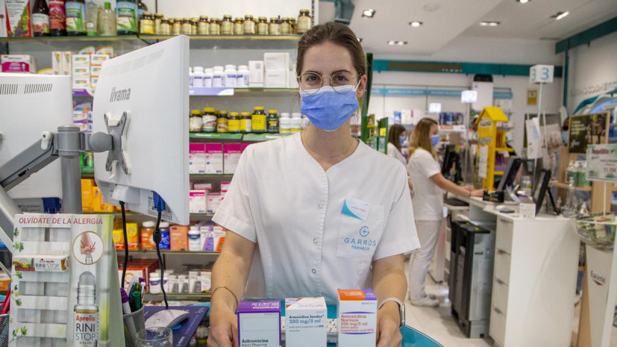 Tres envases de diferentes marcas de jarabes antibióticos en una farmacia leridana.