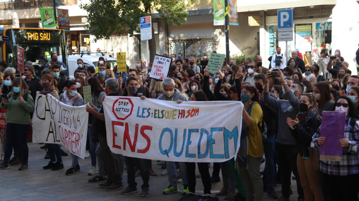 Varios interinos aguantando una pancarta para pedir la regularización de los trabajadores temporales a funcionarios en una concentración en Barcelona.