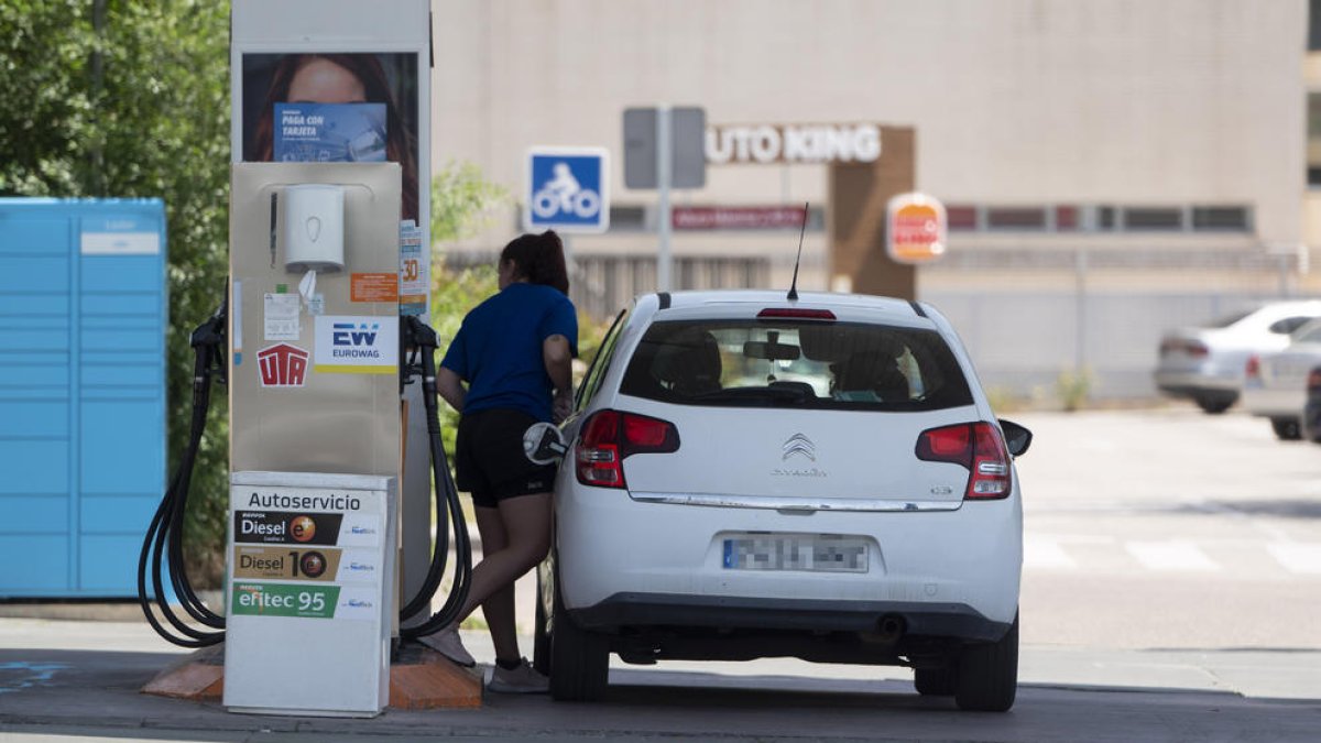 Imagen de archivo de una mujer repostando combustible en una estación de servicio.