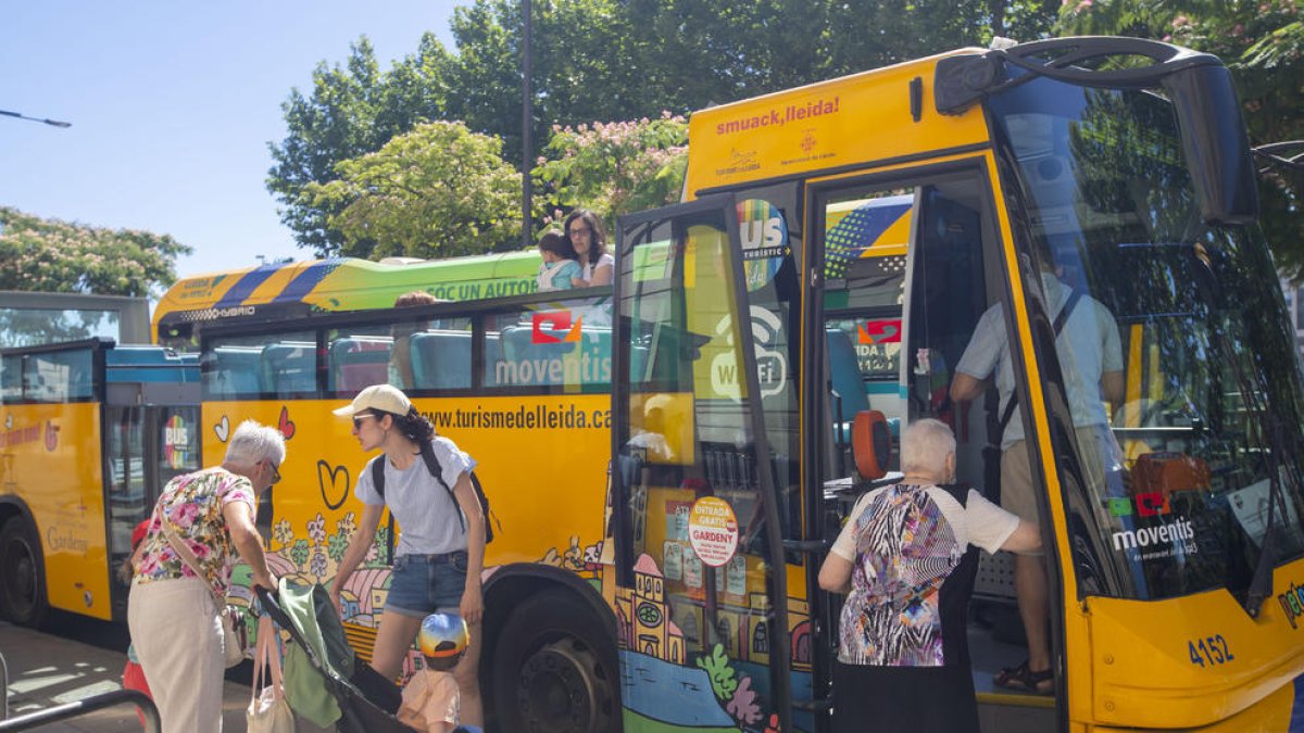 Alguns dels primers usuaris a arribar en el primer viatge del bus turístic ahir.