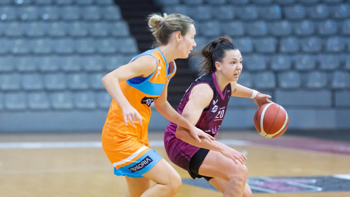 Magali Vilches conduce el balón defendida por Paula Curto.