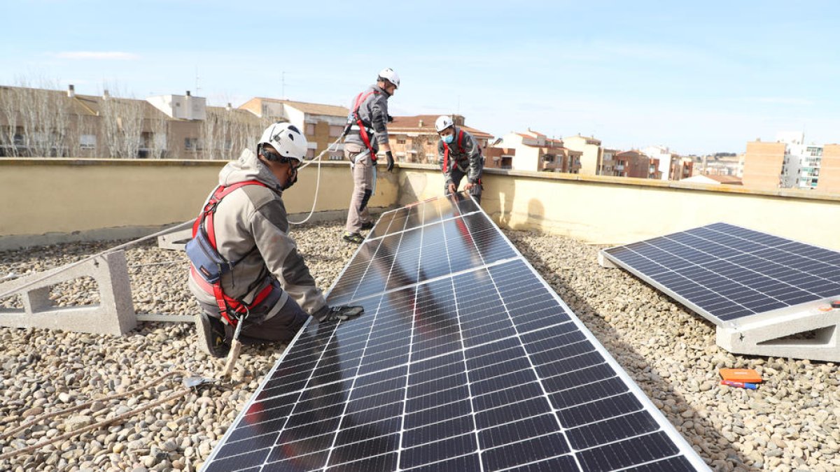 Operarios instalando placas solares en el instituto Maria Rúbies.