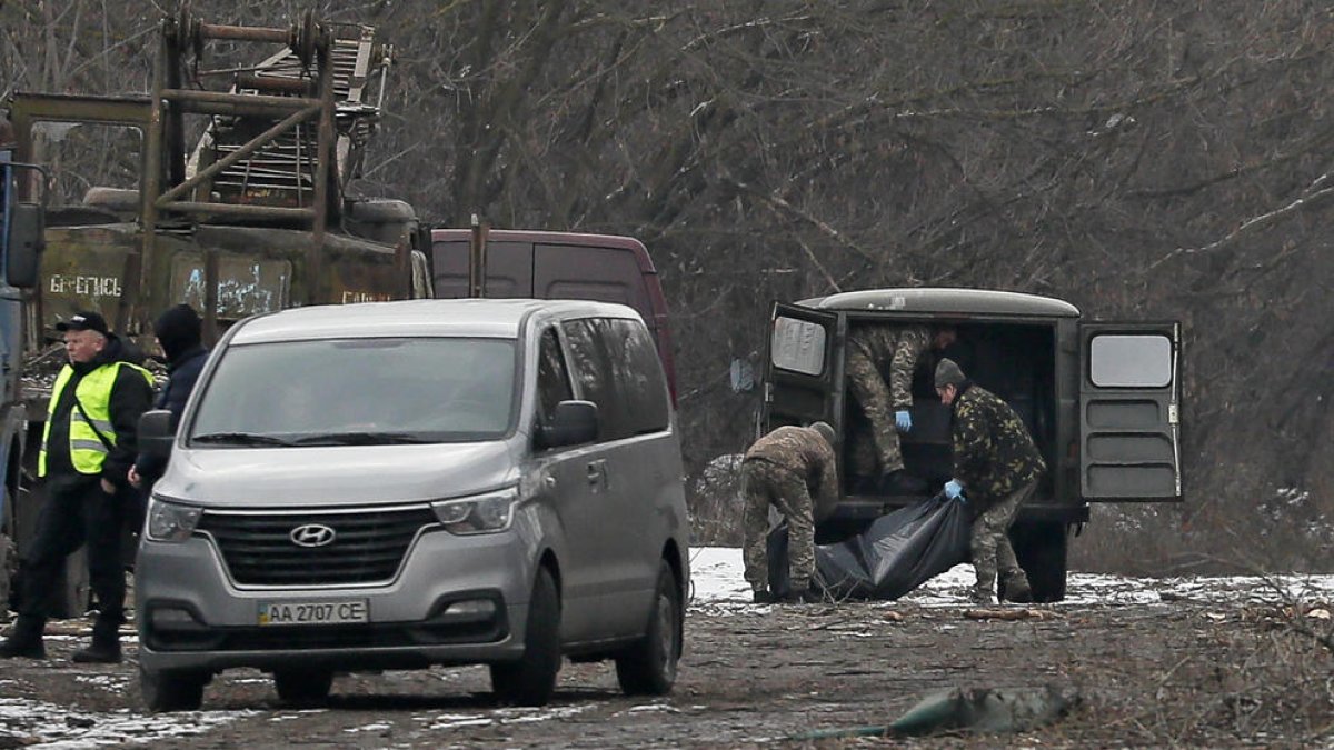 Efectius militars traslladen el cos d’un home mort quan un míssil rus va impactar a Kíiv.