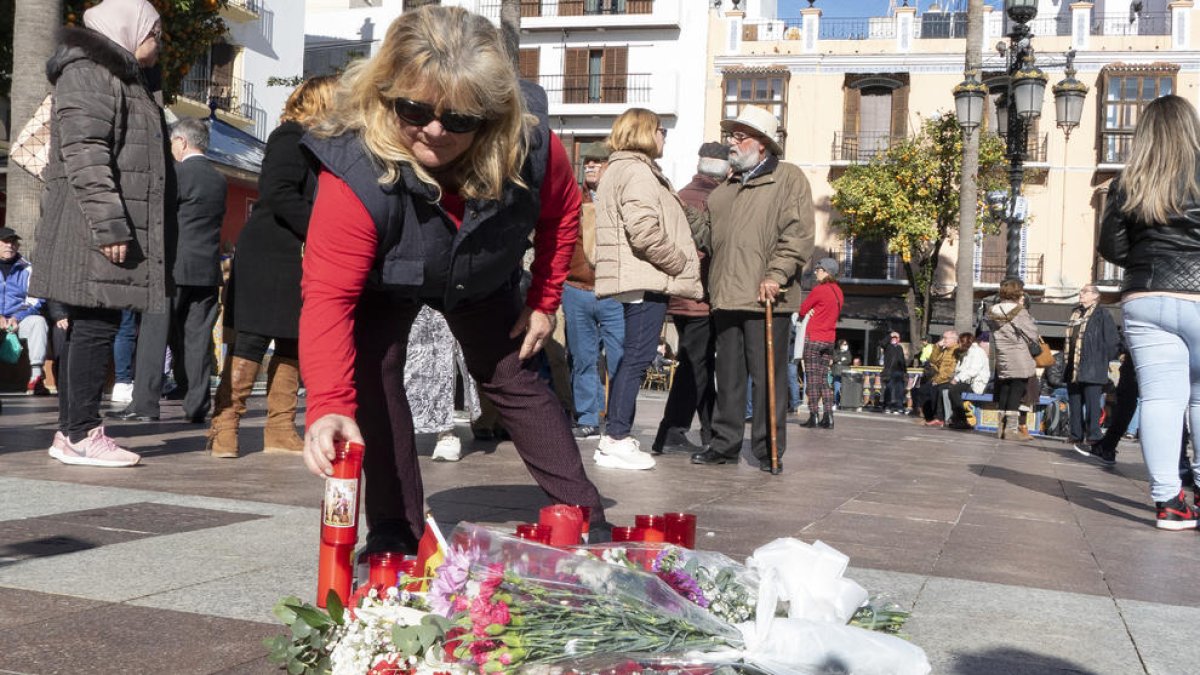 Una mujer coloca una vela en el lugar en el que se produjo el miércoles el ataque en Algeciras. 