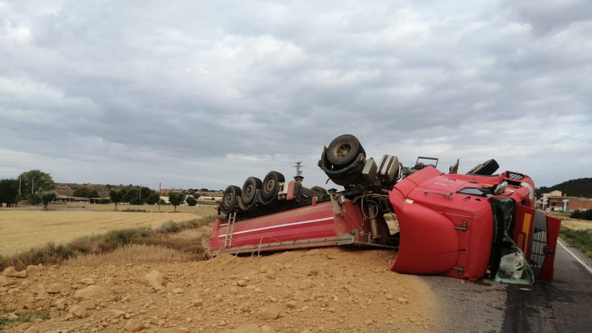 El tràiler va bolcar lateralment i la càrrega va quedar escampada per la calçada.