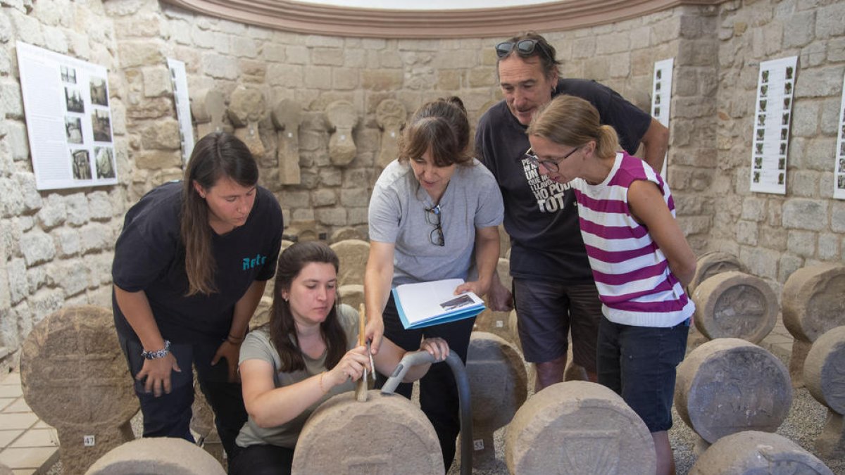 Los especialistas durante la actuación de conservación preventiva de las estelas funerarias. 