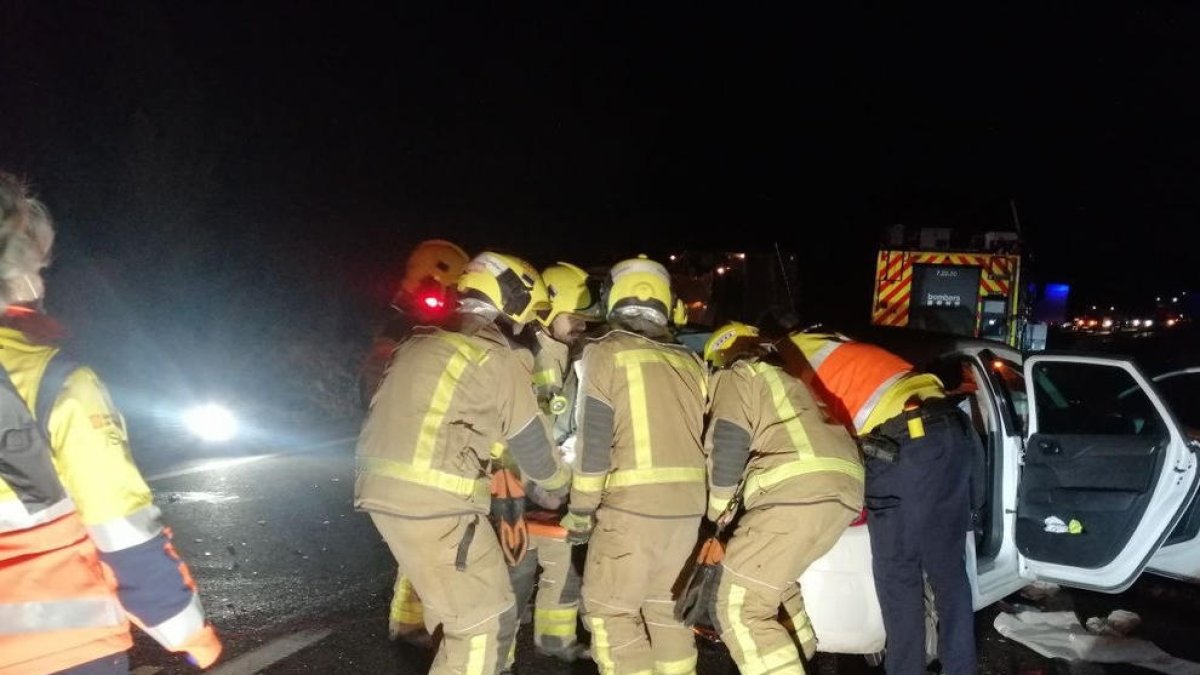 Bombers rescatant ahir un dels conductors que van quedar atrapats al seu vehicle després del xoc.