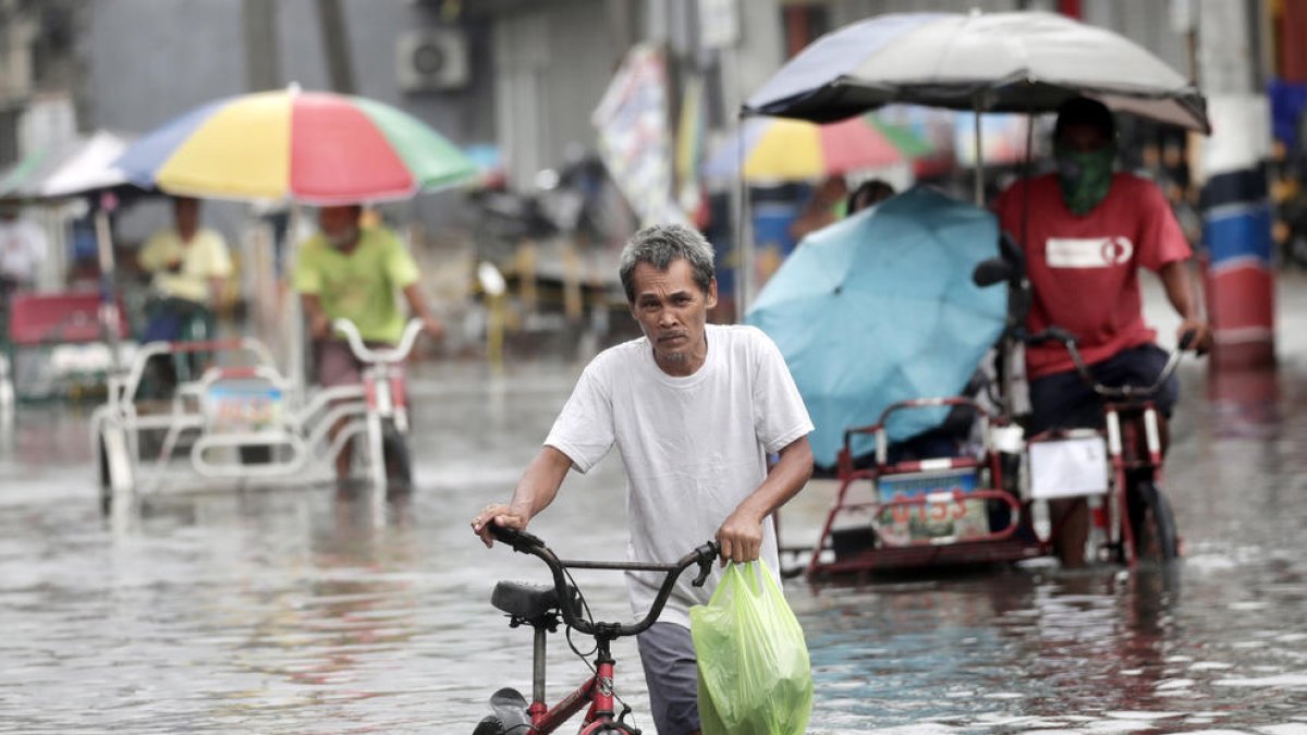 Un home travessa per una carretera inundada a Valenzuela.