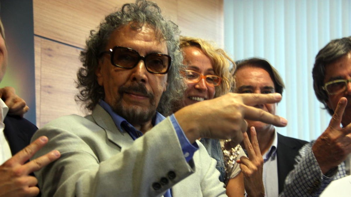 El peluquero Lluís Llongueras hace el símbolo de la tijera con la mano.