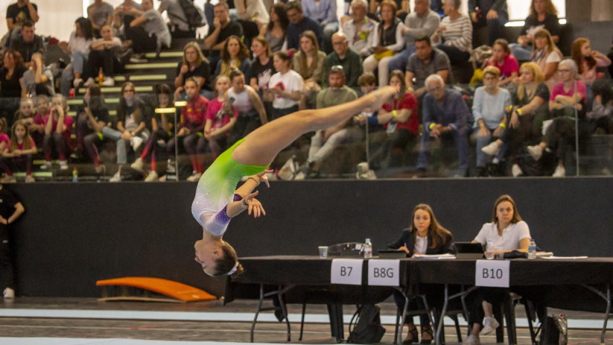 Una de las gimnastas realiza un salto mortal durante la competición disputada ayer en el pabellón Juanjo Garra de Lleida.