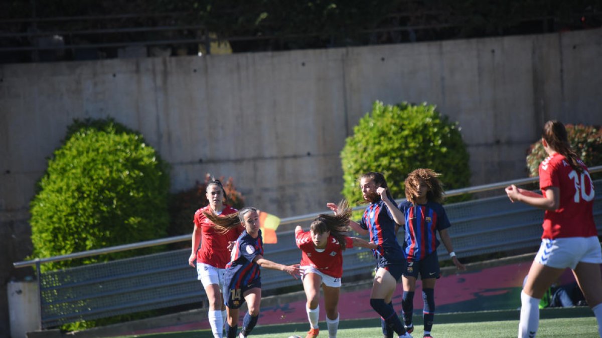 Laura Fernández prova d’escapar-se de la pressió de les blaugranes Bartel i Corrales, amb Vicky López al fons.