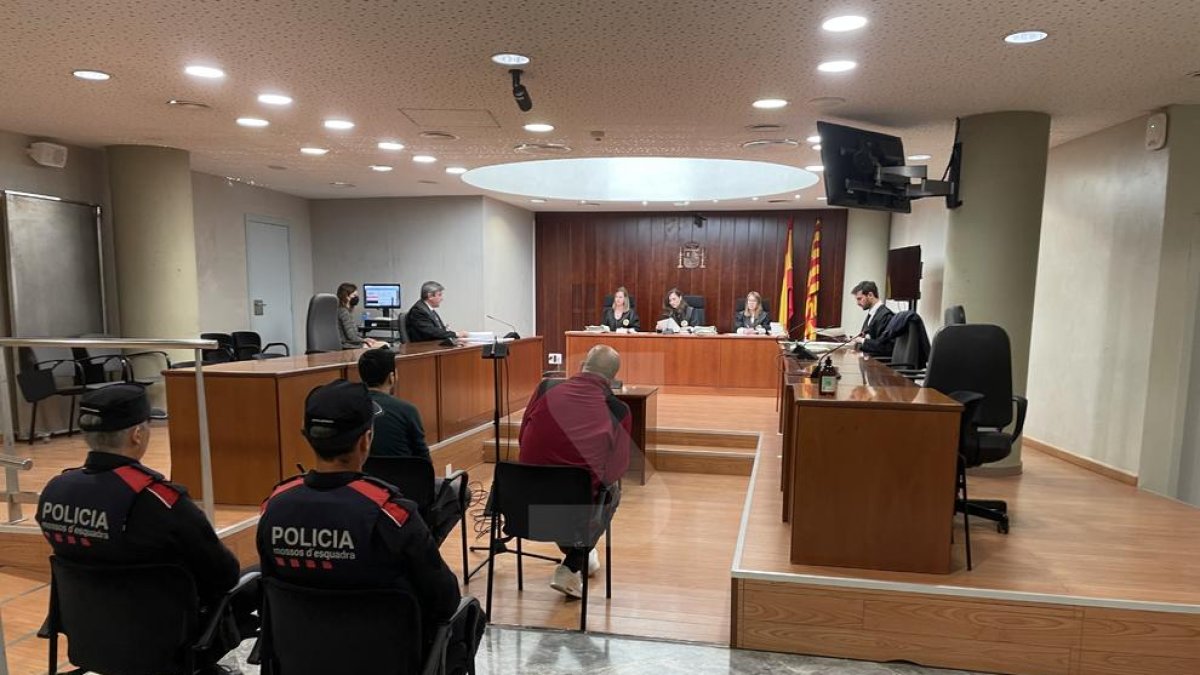 El acusado, de rojo, este miércoles en el juicio en la Audiencia de Lleida, acompañado por traductor.