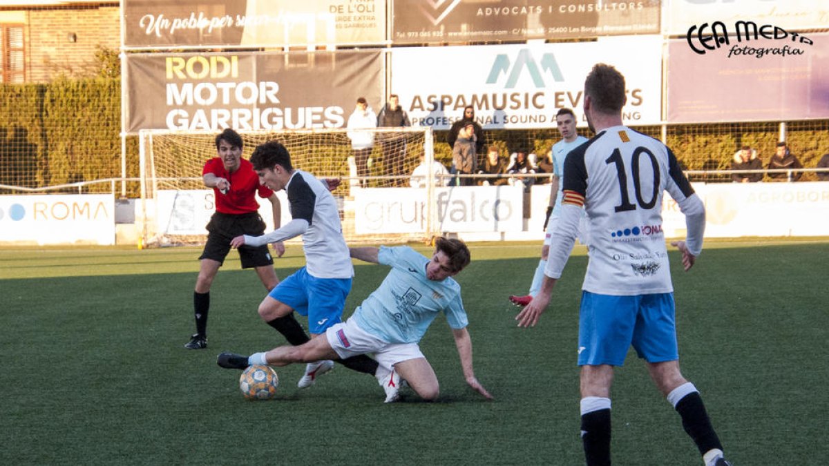 Un jugador de l’Alguaire es llança a terra i s’emporta la pilota davant l’atenta mirada de l’àrbitre.