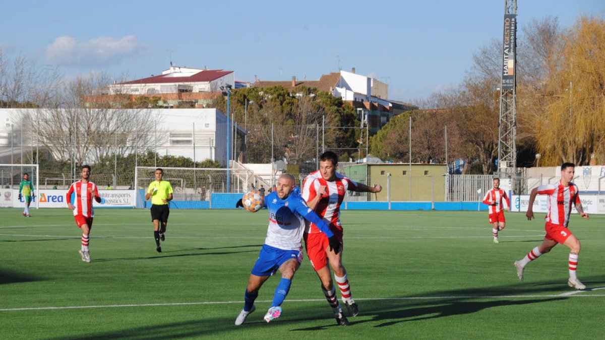 Adrià Fernández, autor d’un gol, pugna amb un jugador rival pel control de la pilota.