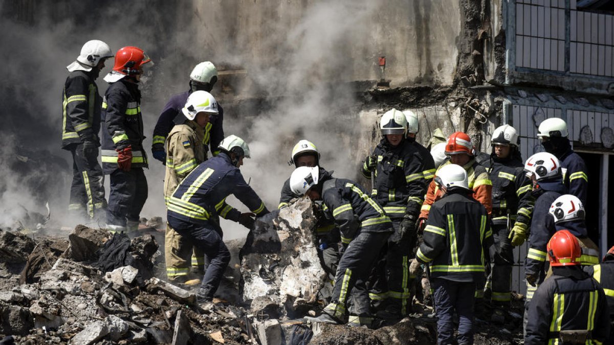 Bombers ucraïnesos busquen víctimes del bombardeig rus entre les ruïnes d’un edifici a Úman.