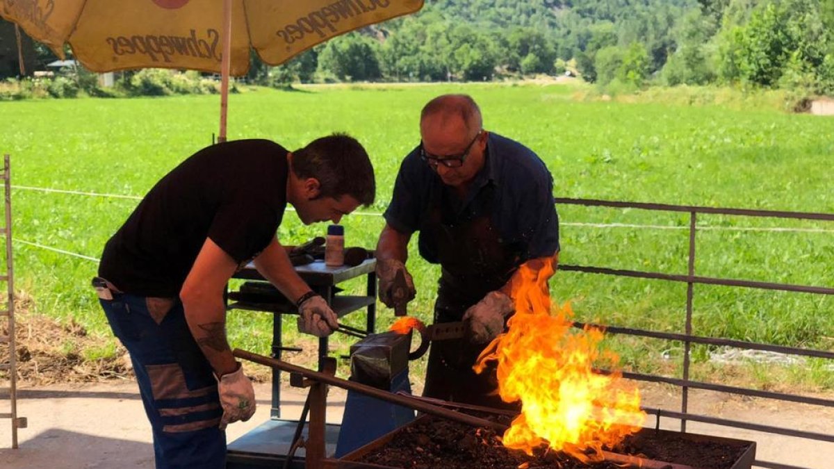 Dos dels forjadors que ahir van participar en la Fira del Ferro de la Vall Ferrera.