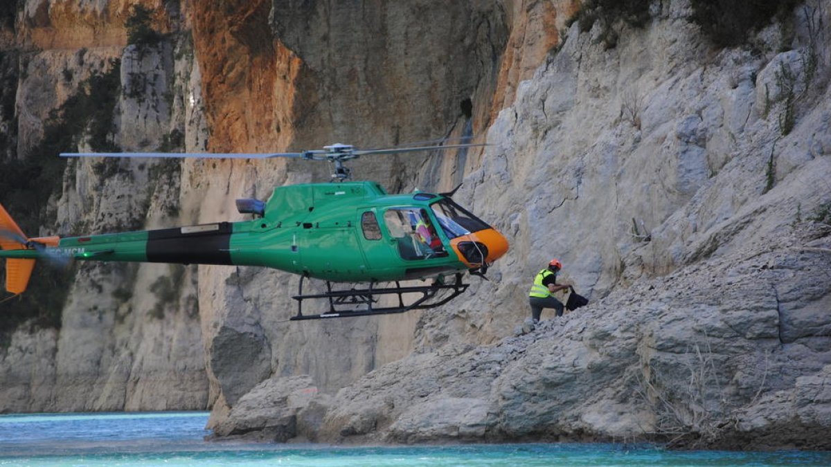 L’helicòpter va descendir fins a la riba per deixar un dels operaris que treballen al pendent de Corçà.